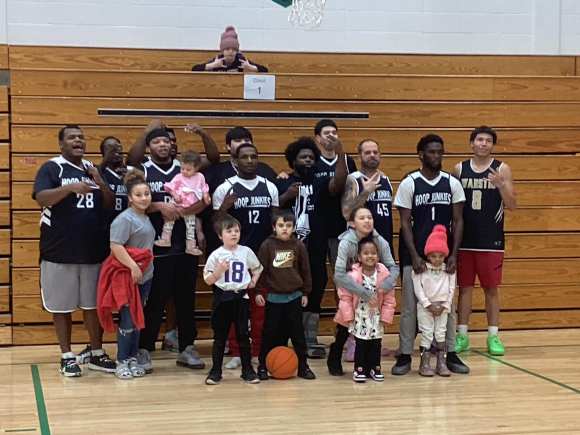 Group photo of a basketball team and their kids